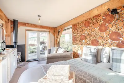 a bedroom with a bed and a wall of logs at 1 Bed in Newton In Bowland oc-h34064 in Newton