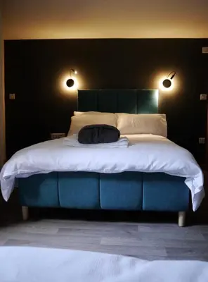 a bedroom with a large bed with a black wall at The Ferny Hoolet in Caton
