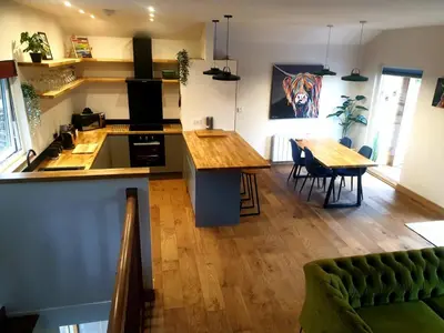 a kitchen and dining room with a table and a counter at The Ferny Hoolet in Caton