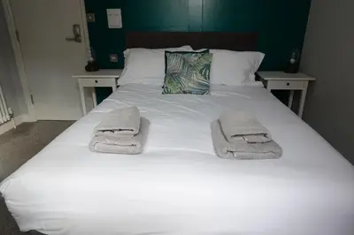a bed with towels on top of it at Victorian Suites Apartment in Southport