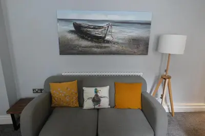 a living room with a couch and a picture of a boat at Victorian Suites Apartment in Southport