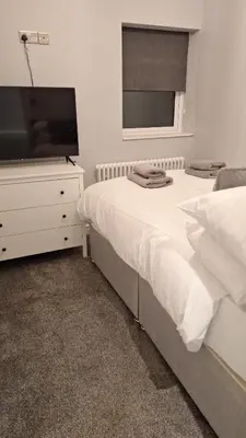 a bedroom with a bed and a dresser with a television at Victorian Suites Apartment in Southport
