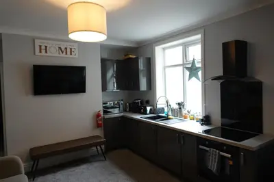 a kitchen with a counter and a sink and a window at Victorian Suites Apartment in Southport