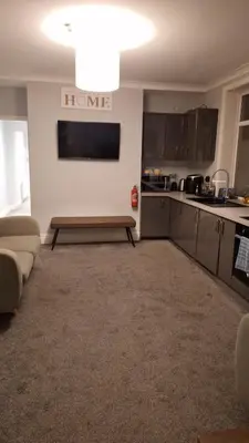 a kitchen with a couch and a table in a room at Victorian Suites Apartment in Southport