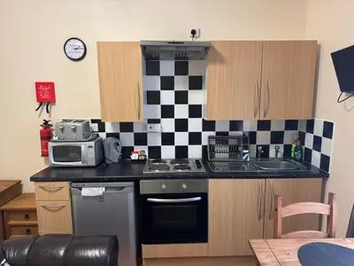 a kitchen with a black and white checkered wall at Woodfield Lodge Apartments in Blackpool