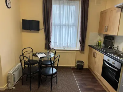 a small kitchen with a table and chairs and a window at Woodfield Lodge Apartments in Blackpool