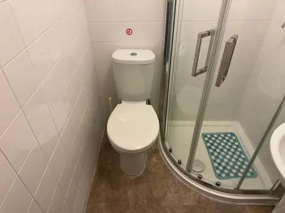a small bathroom with a toilet and a shower at Woodfield Lodge Apartments in Blackpool