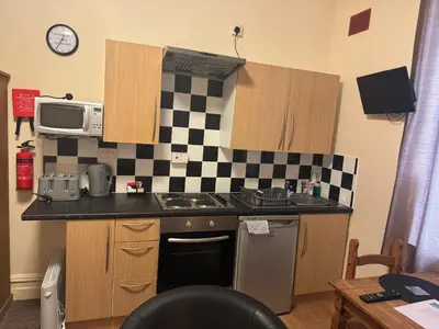 a kitchen with a sink and a stove and a microwave at Woodfield Lodge Apartments in Blackpool