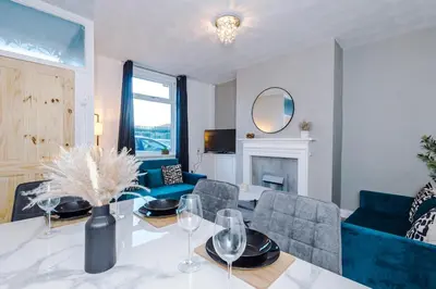 a living room with a table with wine glasses at Presented by LTJ PrimeKey Properties - NEW! 4 Bed plus Sofa Bed, Perfect for Contractors in Saint Helens