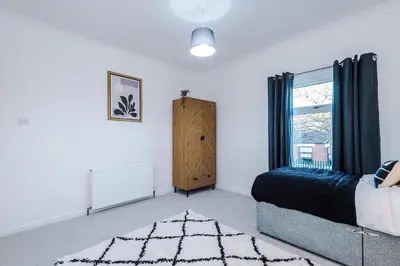 a bedroom with a bed and a window at Presented by LTJ PrimeKey Properties - NEW! 4 Bed plus Sofa Bed, Perfect for Contractors in Saint Helens