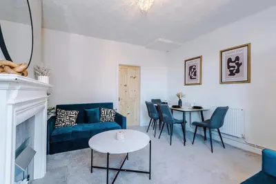 a living room with a blue couch and a table at Presented by LTJ PrimeKey Properties - NEW! 4 Bed plus Sofa Bed, Perfect for Contractors in Saint Helens