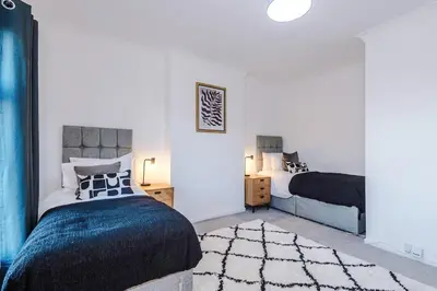 a bedroom with two beds and a rug at Presented by LTJ PrimeKey Properties - NEW! 4 Bed plus Sofa Bed, Perfect for Contractors in Saint Helens