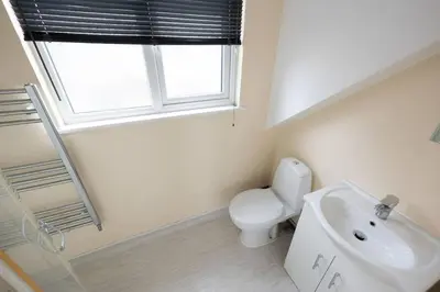 a bathroom with a toilet and a sink and a window at Modern Family Home Near Liverpool City in Wallasey