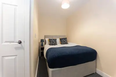 a bedroom with a bed with a blue blanket at Modern Family Home Near Liverpool City in Wallasey