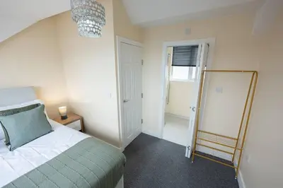 a bedroom with a bed and a mirror in it at Modern Family Home Near Liverpool City in Wallasey