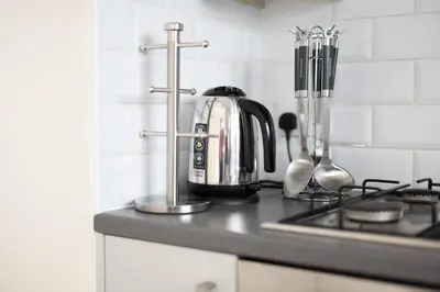 a kitchen counter with a coffee pot on a stove at Modern Family Home Near Liverpool City in Wallasey