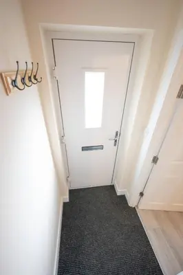 a hallway with a white door with a window at Modern Family Home Near Liverpool City in Wallasey