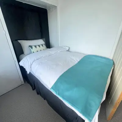 a bed with a blue blanket on top of it at Stylish family home with cinema-style lounge near Blackpool in Blackpool