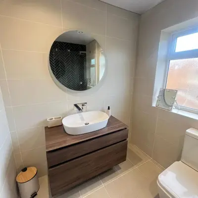a bathroom with a sink and a mirror at Stylish family home with cinema-style lounge near Blackpool in Blackpool