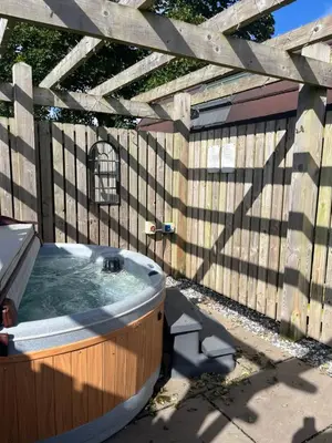 a bath tub in a backyard with a wooden fence at Mill House Farm Pods - Lapwing Lodge in Pilling