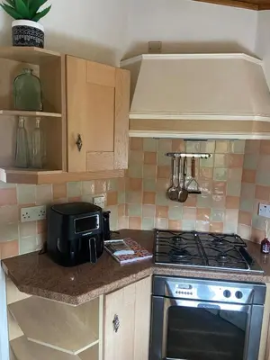 a kitchen with a stove and a microwave at Kingfisher Cosy Lakeside Lodge in Carnforth