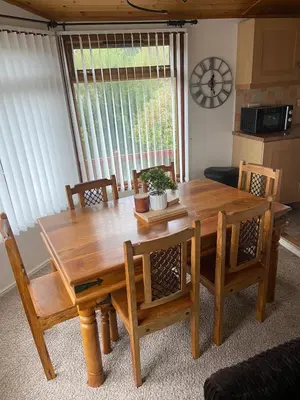 a dining room table and chairs with a table and a window at Kingfisher Cosy Lakeside Lodge in Carnforth