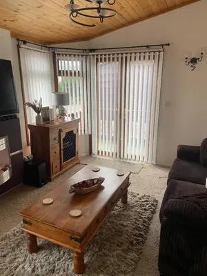 a living room with a coffee table and a couch at Kingfisher Cosy Lakeside Lodge in Carnforth