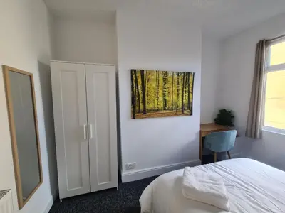 a bedroom with a bed and a painting on the wall at 3 Bed - Maisonette - Albert Road in Morecambe