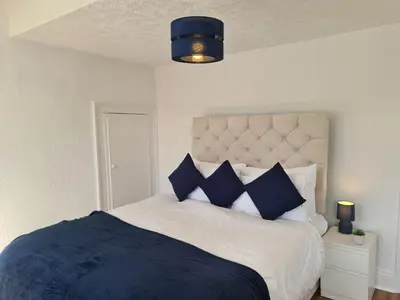 a bedroom with a bed with blue and white pillows at 3 Bed - Maisonette - Albert Road in Morecambe