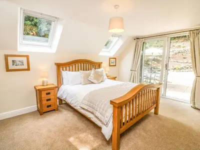 a bedroom with a wooden bed and a window at The Coach House in Carnforth