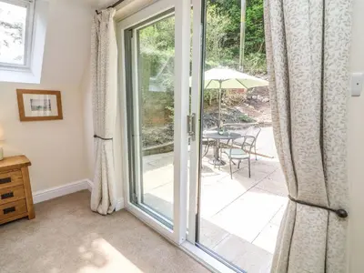 a sliding glass door leading to a patio with a table at The Coach House in Carnforth