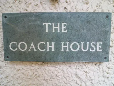 a sign that says the coach house on a wall at The Coach House in Carnforth