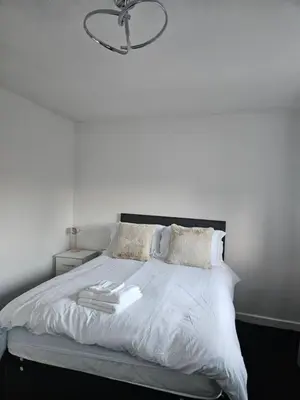 a bedroom with a white bed with a chandelier at Relaxing and Comfort in Preston