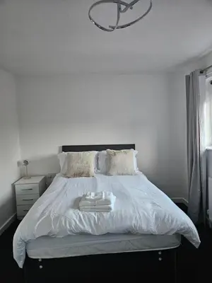 a bedroom with a white bed with a light fixture at Relaxing and Comfort in Preston