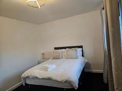 a bedroom with a bed with white sheets and pillows at Relaxing and Comfort in Preston