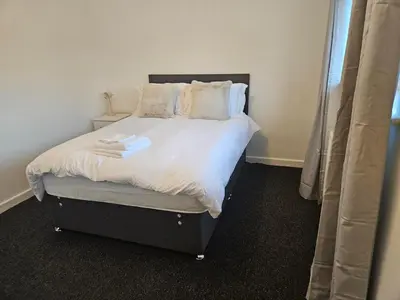 a bedroom with a bed with white sheets and pillows at Relaxing and Comfort in Preston