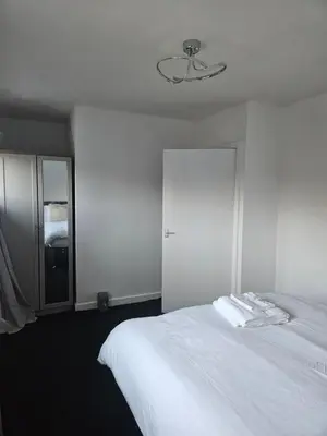 a bedroom with a white bed and a ceiling fan at Relaxing and Comfort in Preston