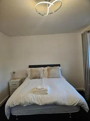 a bedroom with a white bed with a chandelier at Relaxing and Comfort in Preston