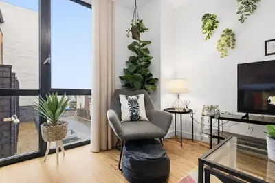 a living room with a chair and a large window at Central Liverpool Baltic Apartment Sleeps 7 in Liverpool