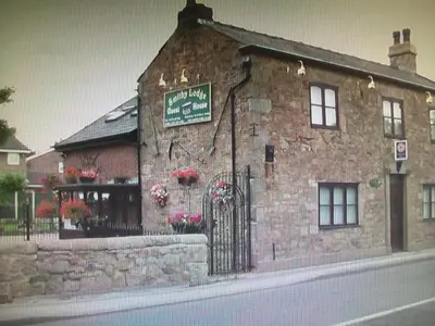 a brick building with a gate in front of it at Smithy lodge guest house in Leyland
