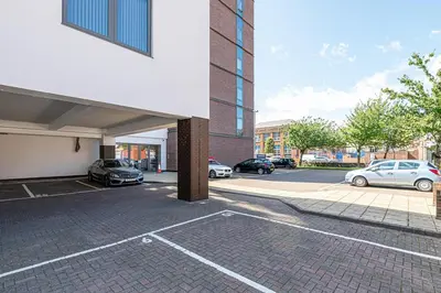 a parking lot with cars parked in front of a building at #94 Lux Crosby Gardens Apartment 2 beds 2 baths in Waterloo