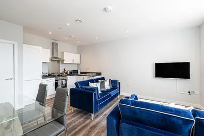 a living room with blue couches and a kitchen at #94 Lux Crosby Gardens Apartment 2 beds 2 baths in Waterloo