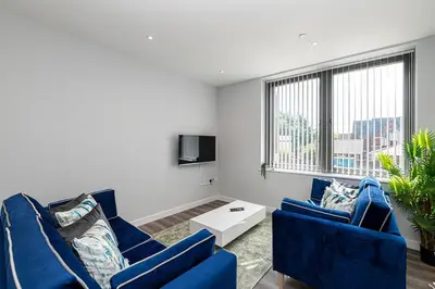 a living room with two blue couches and a tv at #94 Lux Crosby Gardens Apartment 2 beds 2 baths in Waterloo