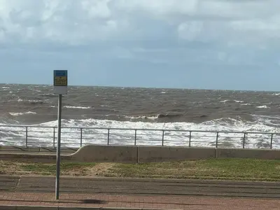 a sign on the side of a road near the ocean at Sea View Camper Van in Blackpool