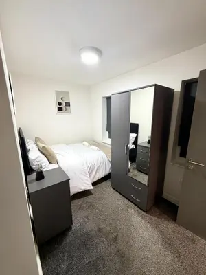 a bedroom with a bed and a large mirror at Home in Preston City Center in Preston