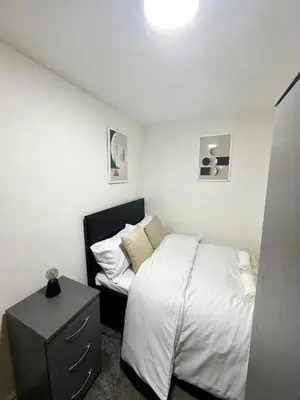 a small bedroom with a bed and a night stand at Home in Preston City Center in Preston