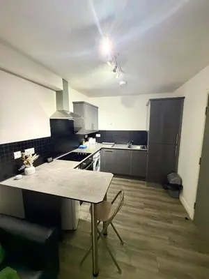 a kitchen with a table in the middle of it at Home in Preston City Center in Preston