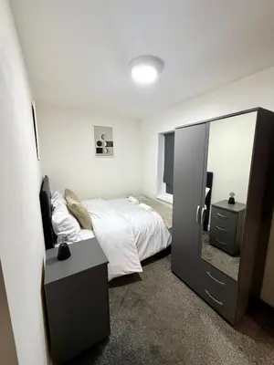 a bedroom with a bed and a large mirror at Home in Preston City Center in Preston
