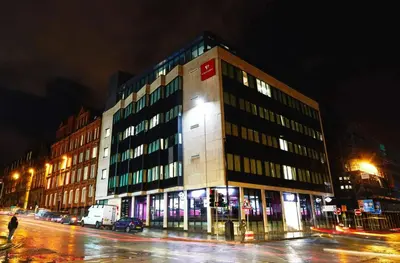 a large building on a city street at night at For Students Only Cozy Stays at Crosshall Street in Liverpool