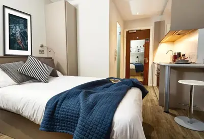 a bedroom with a bed with a blue blanket on it at For Students Only Cozy Stays at Crosshall Street in Liverpool